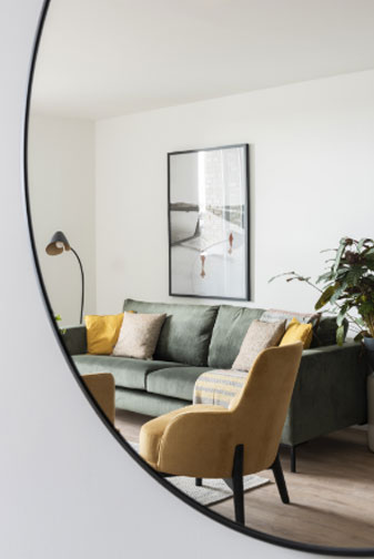 A Sitting room reflected in a cropped mirror.